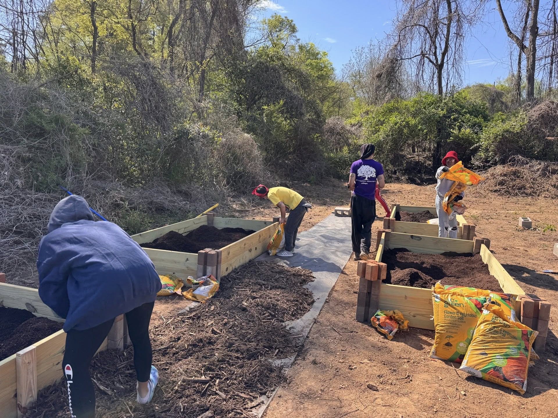 Volunteers building raised garden beds together